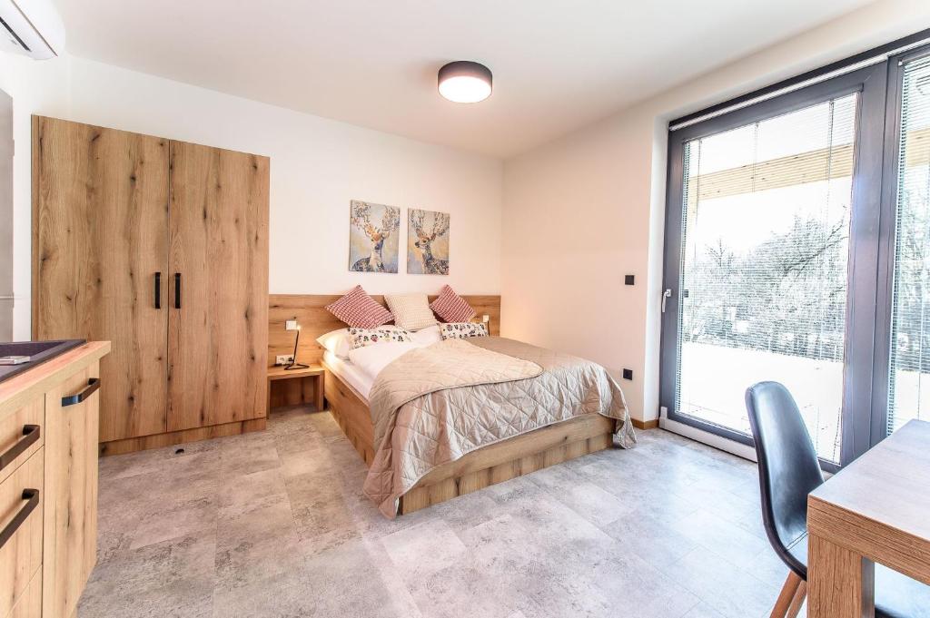 um quarto com uma cama e uma grande janela em APARTMÁNY BLUDOVEČEK em Bludov