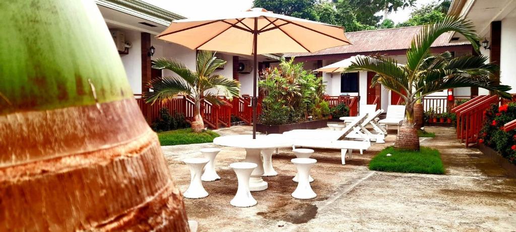 une terrasse avec une table, des chaises et un parasol dans l'établissement Casi Verde Panglao, à Panglao