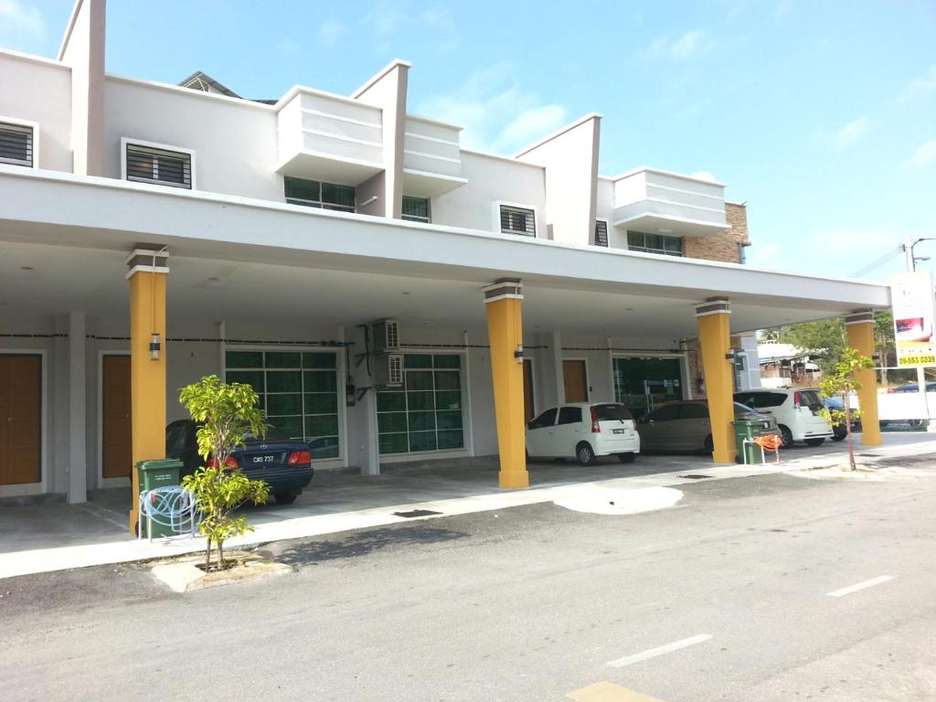 un gran edificio blanco con columnas amarillas y coches estacionados en GOLDEN GUEST HOUSE KUANTAN en Kuantan