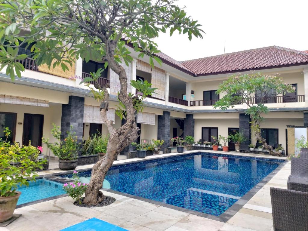 a swimming pool in front of a villa at Radha Bali Hotel in Kuta