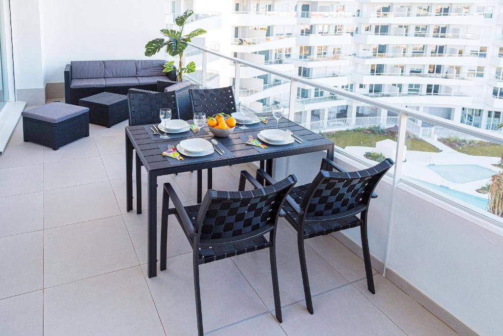 een eettafel en stoelen op het balkon van een appartement bij Global Properties, Apartamento para 6 personas con terraza in Canet de Berenguer