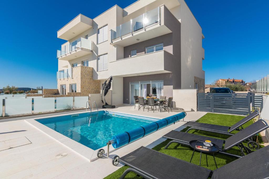 a villa with a swimming pool in front of a house at Vila Nena in Vodice