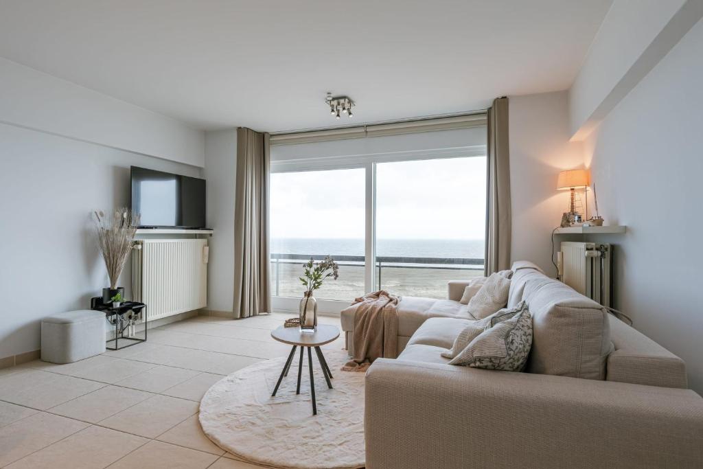 - un salon avec un canapé et une vue sur l'océan dans l'établissement Bright apartment with beautiful sea view, à Middelkerke