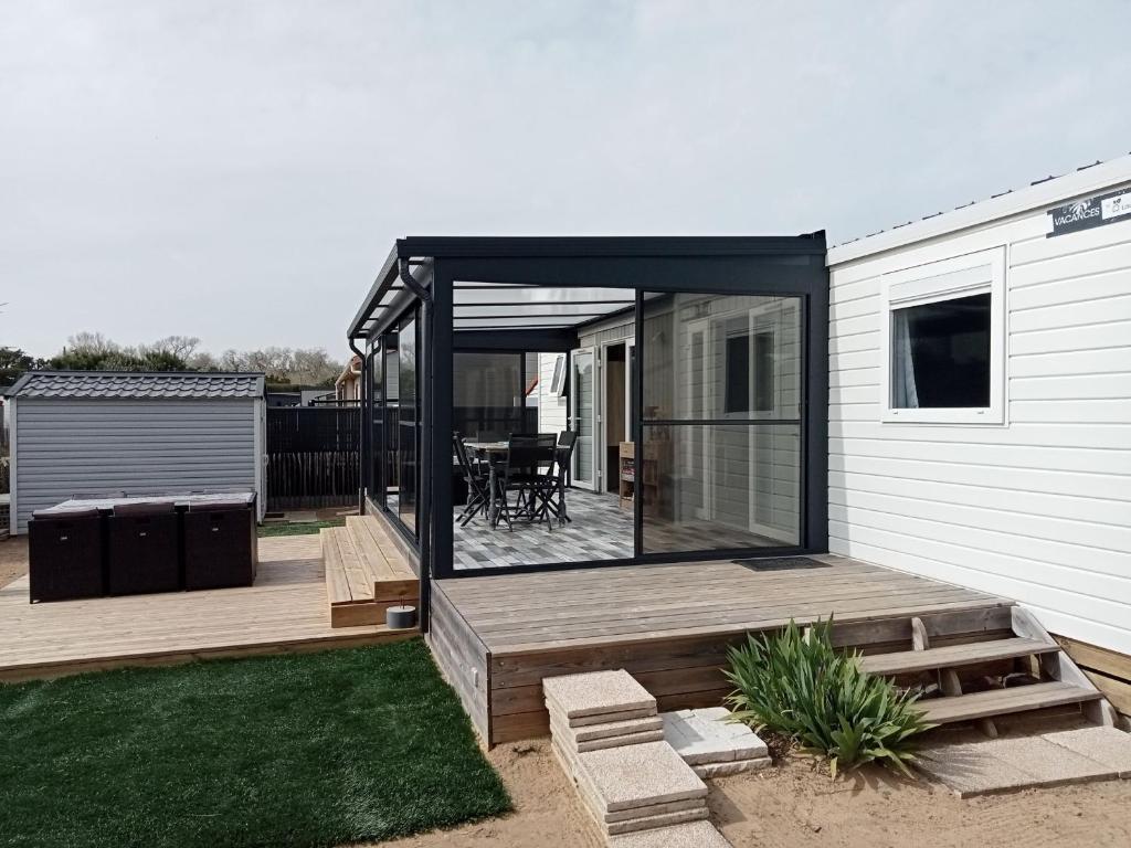 une terrasse avec une table sur une maison dans l'établissement Résidence avec piscine, chalet pour 6, à Saint-Hilaire-de-Riez