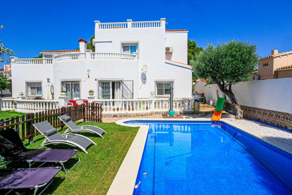 a villa with a swimming pool in front of a house at Villa Albada - ONLY FAMILIES in Miami Platja