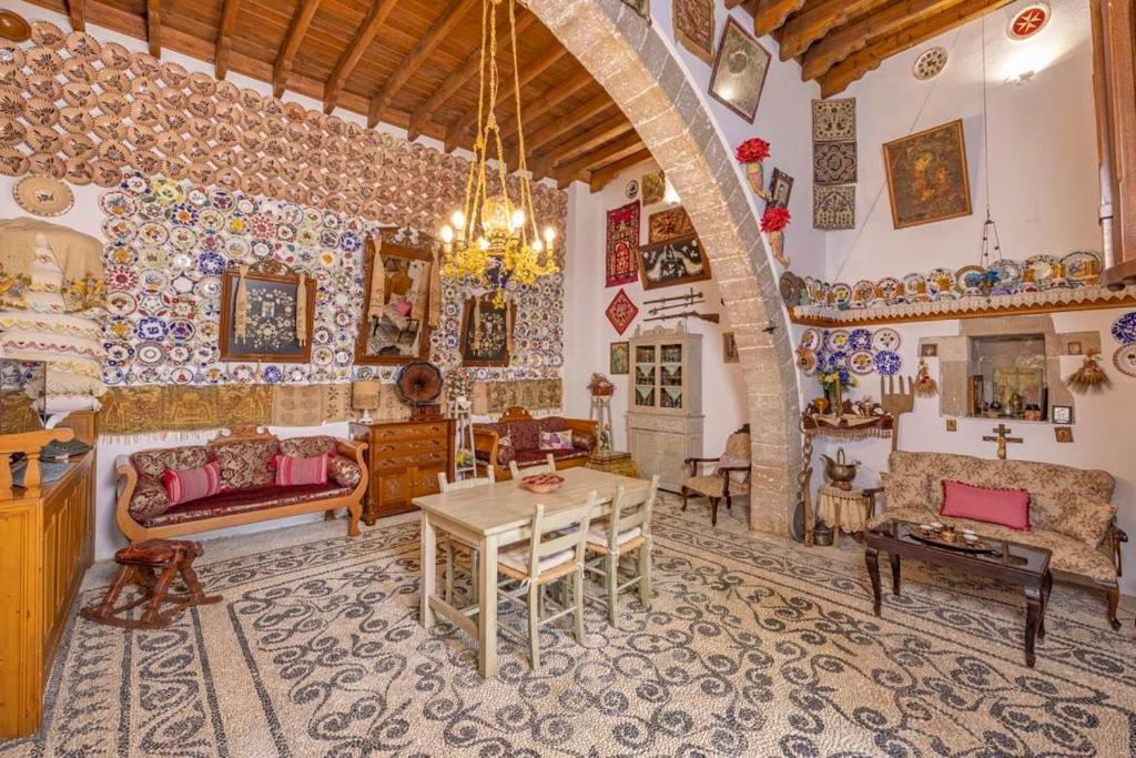 een woonkamer met meubilair en een grote boog bij Beautiful historic house in Koskinou