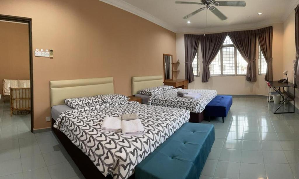 Un dormitorio con dos camas y un sofá azul. en Dino House, en Taiping