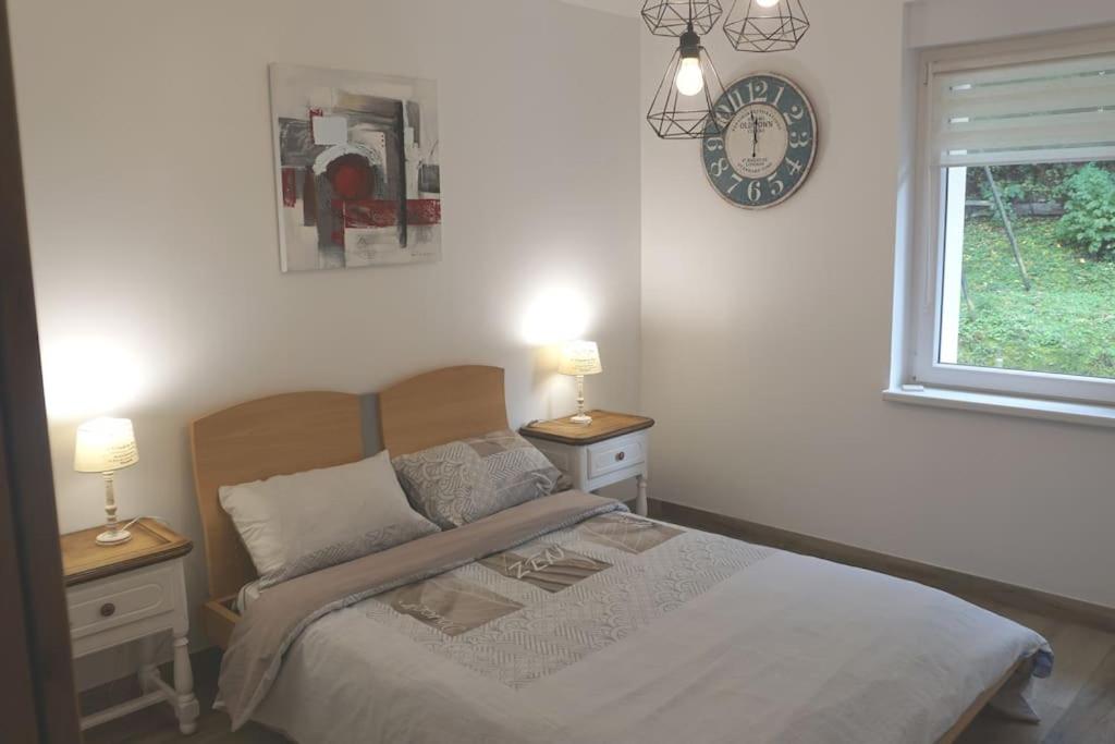 a bedroom with a bed and a clock on the wall at Le bord de Sarre in Sarreguemines