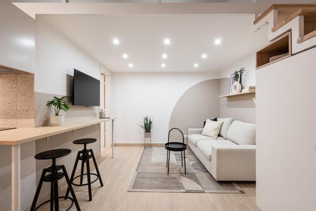 uma sala de estar e cozinha com um sofá e banco em KL35- Boutique Apartments, Best Location. By BQA em Budapeste