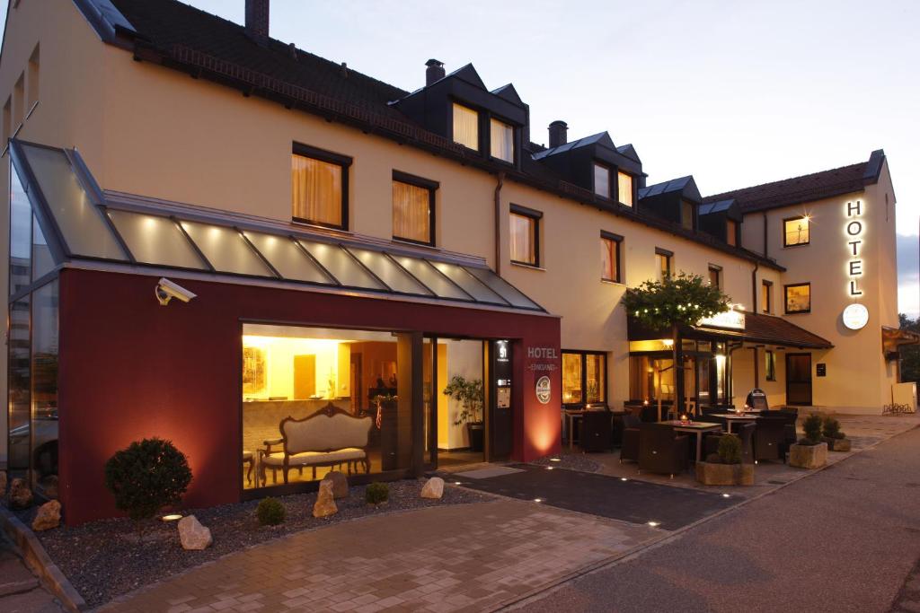 een hotel met een gebouw met een bankje ervoor bij Hotel Restaurant Weihenstephaner Stuben in Landshut