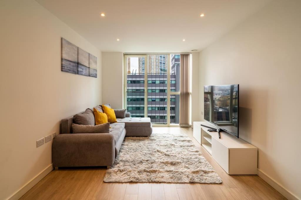 a living room with a couch and a tv at Luxury Flat Croydon in Croydon