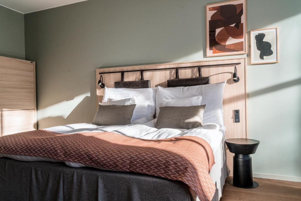 a bedroom with a large bed with white sheets and pillows at Quality Hotel Grand, Borås in Borås