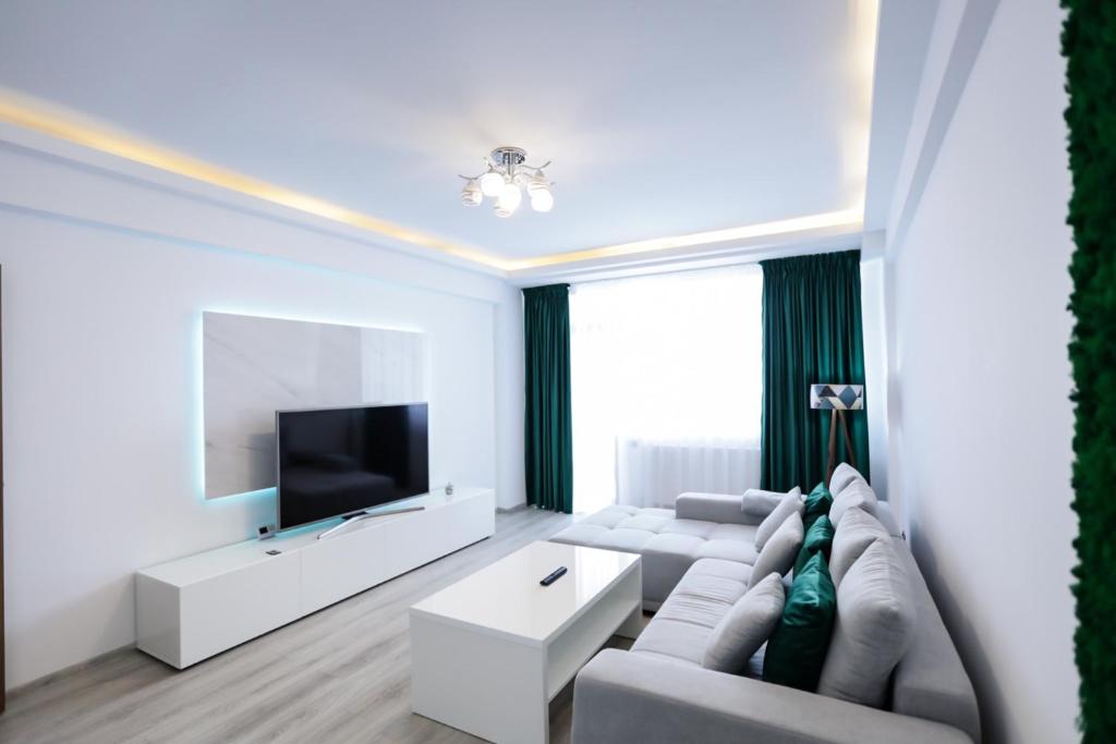 een woonkamer met een bank en een tv bij Isaran Apartament with Panoramic City View in Braşov