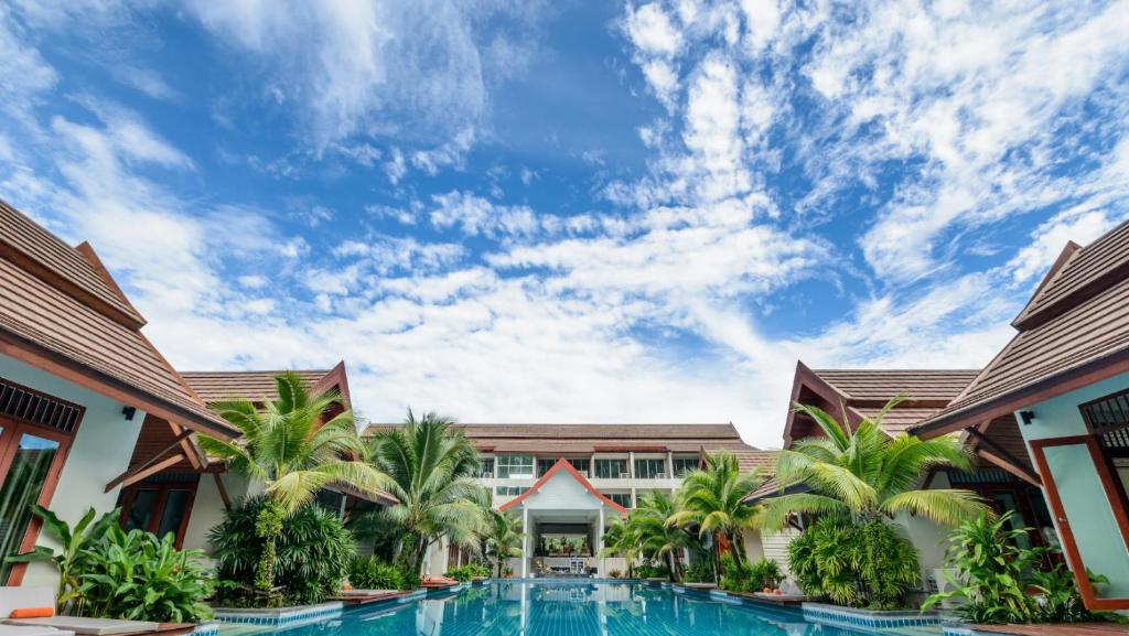 uma vista para o resort com uma piscina e palmeiras em KDC House em Garut