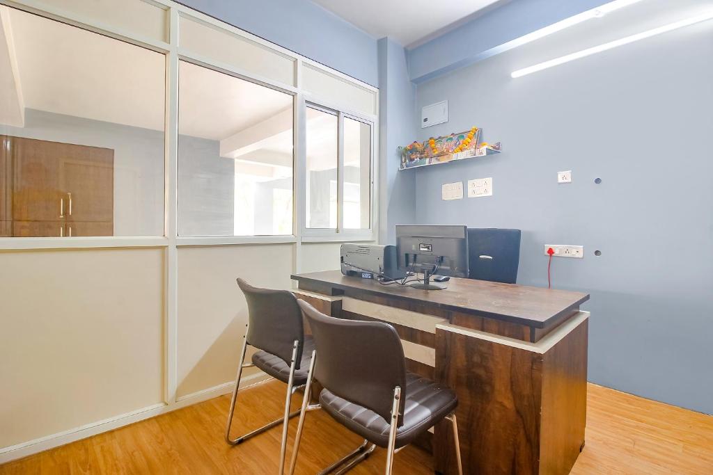 an office with two chairs and a desk with a computer at FabHotel Corner Courtyard in Kondapur