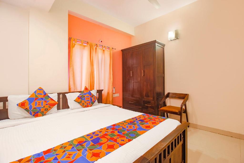 a bedroom with a bed and a wooden cabinet at FabExpress Corner Courtyard - Nr Botanical Garden, Kondapur in Kondapur