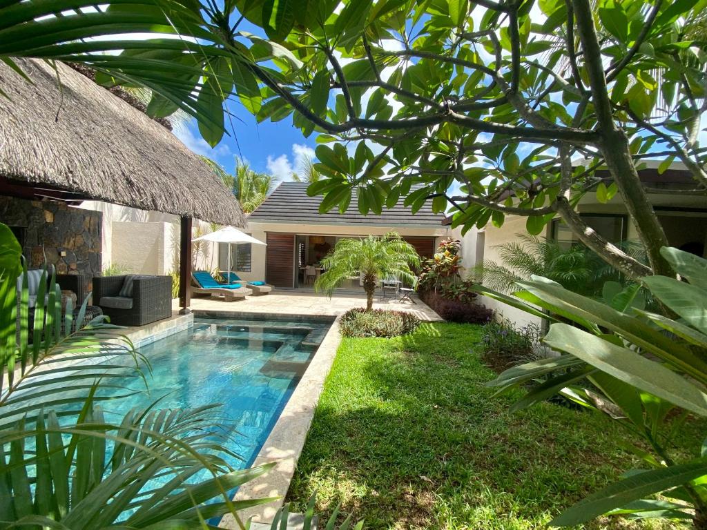 a backyard with a swimming pool and a house at Grand Baie - Très belle villa 3 chambres in Grand-Baie