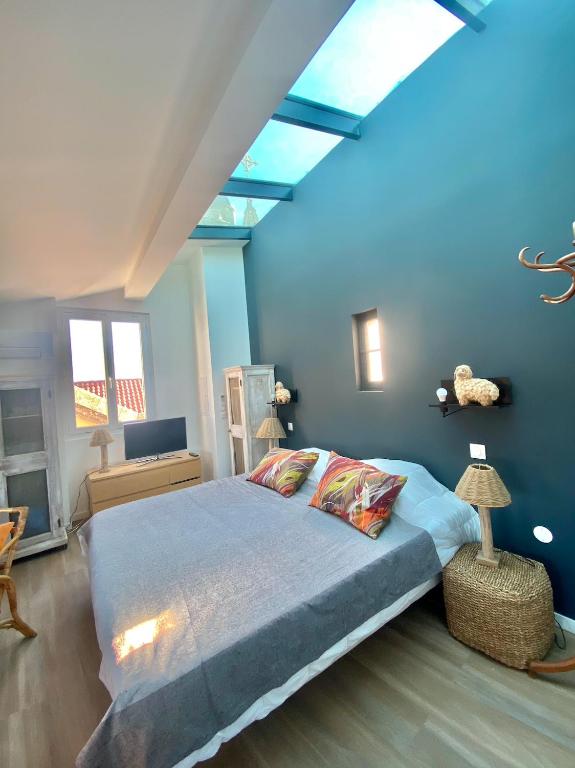 une chambre avec un grand lit aux murs bleus dans l'établissement les nuits étoilées, studio terrasse aperçu mer, très lumineux, AC, 100m du port Sanary, à Sanary-sur-Mer
