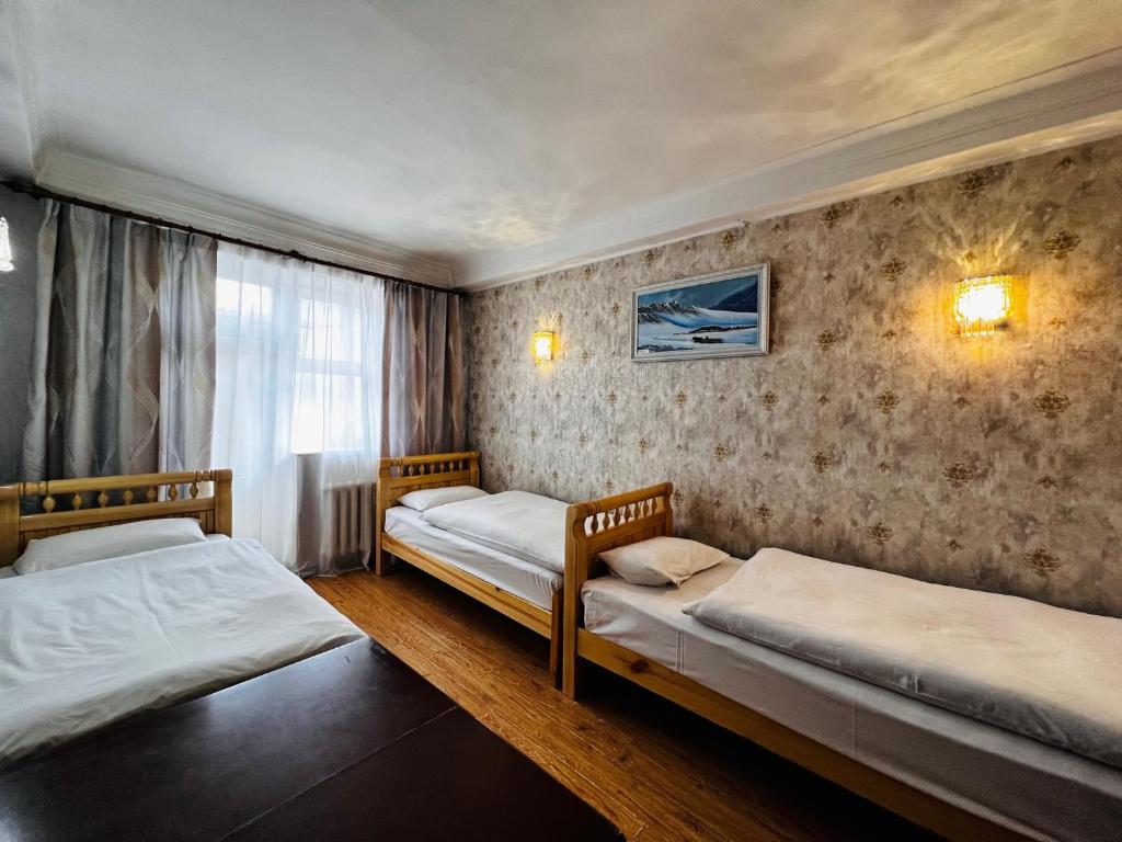 a bedroom with two beds and a window at Khongor Guest house & Tours in Ulaanbaatar