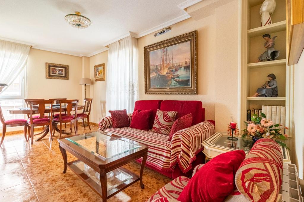 uma sala de estar com um sofá vermelho e uma mesa em Casa Julia playa de Berria em Santoña