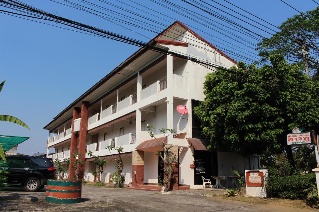 a white building with a street in front of it at OYO 75420 Howto Hotel in Chiang Mai