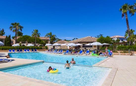 un groupe de personnes dans une piscine d'un complexe hôtelier dans l'établissement Superbe T2 Sognu di Mare, à Linguizzetta