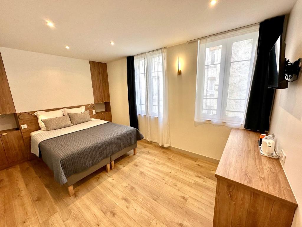 a bedroom with a bed and a large window at Hotel Zora in Paris