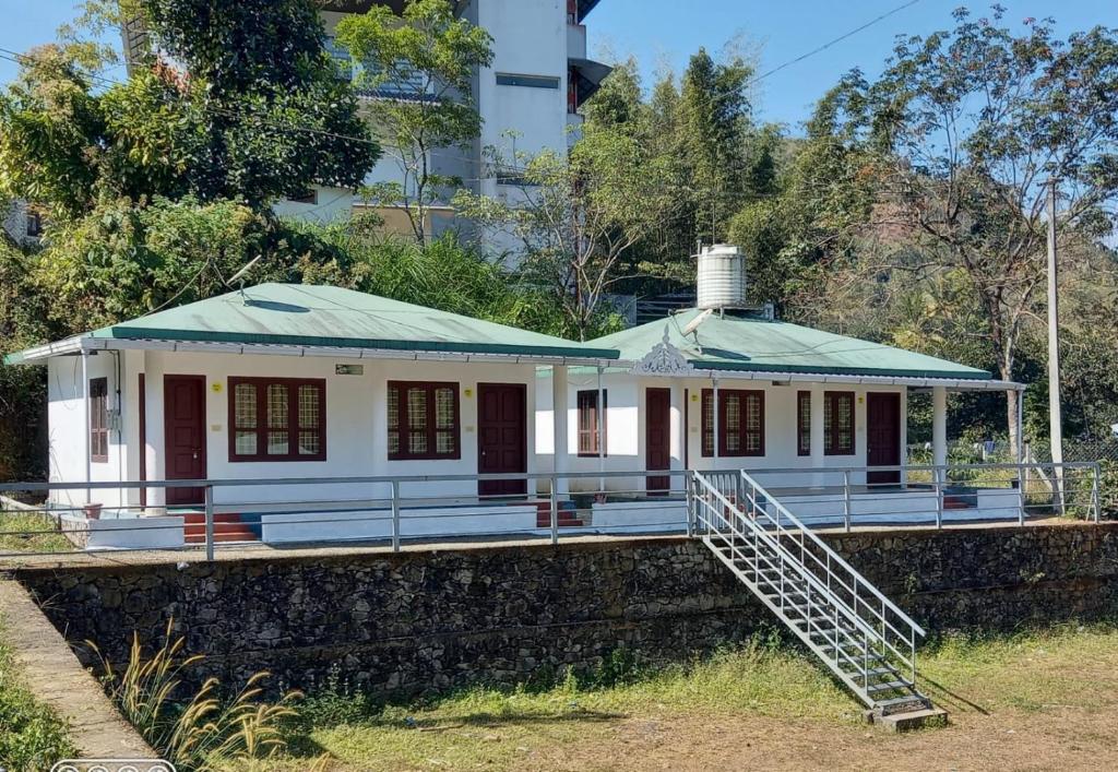 une maison avec un toit vert au-dessus d'un mur dans l'établissement Mountain View cottage Mankulam, à Munnar