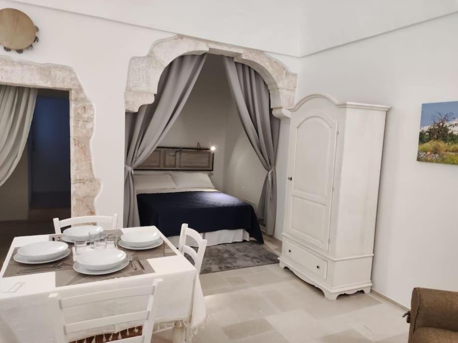 - une chambre avec un lit, une table et des chaises dans l'établissement Casa Garibaldi 246 Ostuni centro storico, à Ostuni