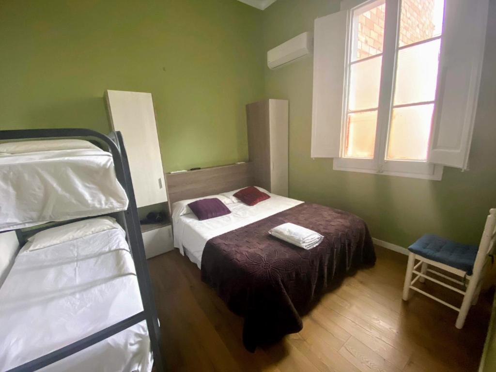 1 dormitorio con 1 cama y 2 literas en SANT ANTONI HOSTAL, Sustainable Tourism, en Barcelona