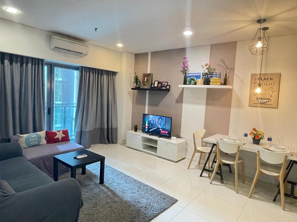 een woonkamer met een bank en een tafel bij Mercu Summer Suite KLCC by Kuminshu in Kuala Lumpur