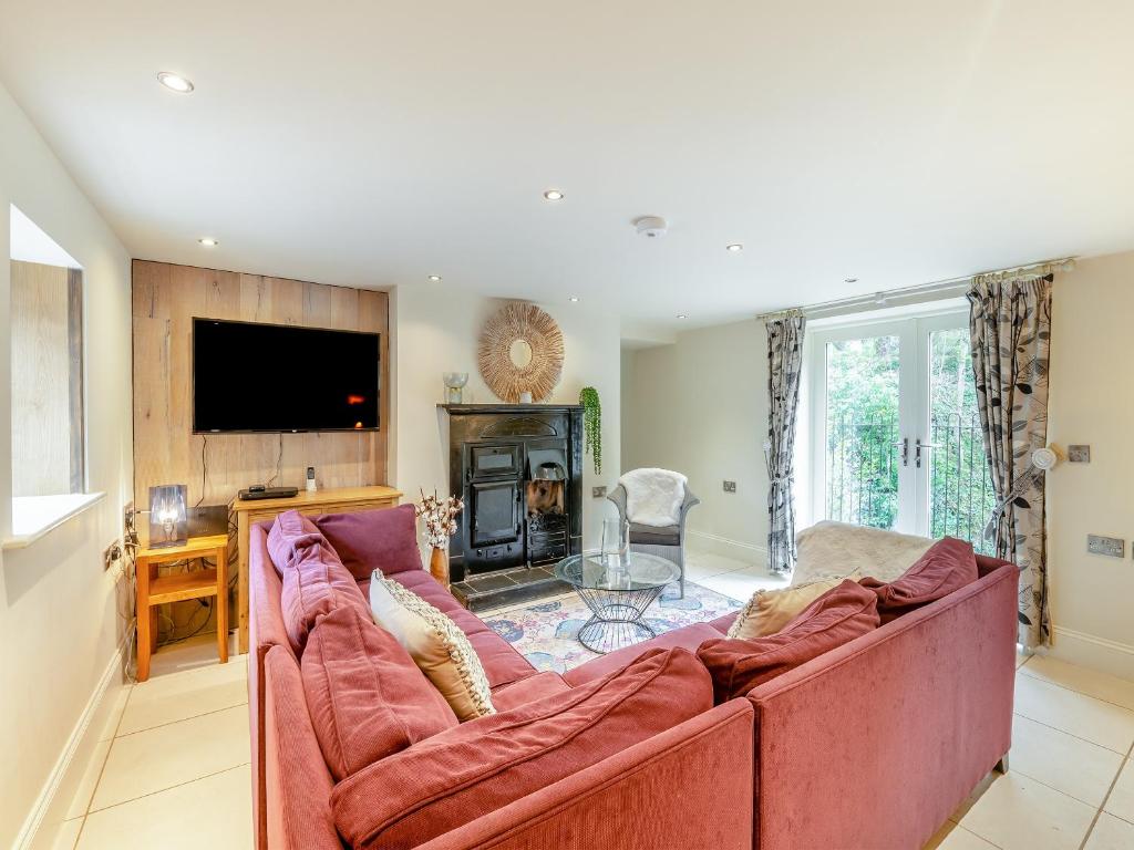 uma sala de estar com um sofá grande e uma televisão em Home Farm House em Sandsend