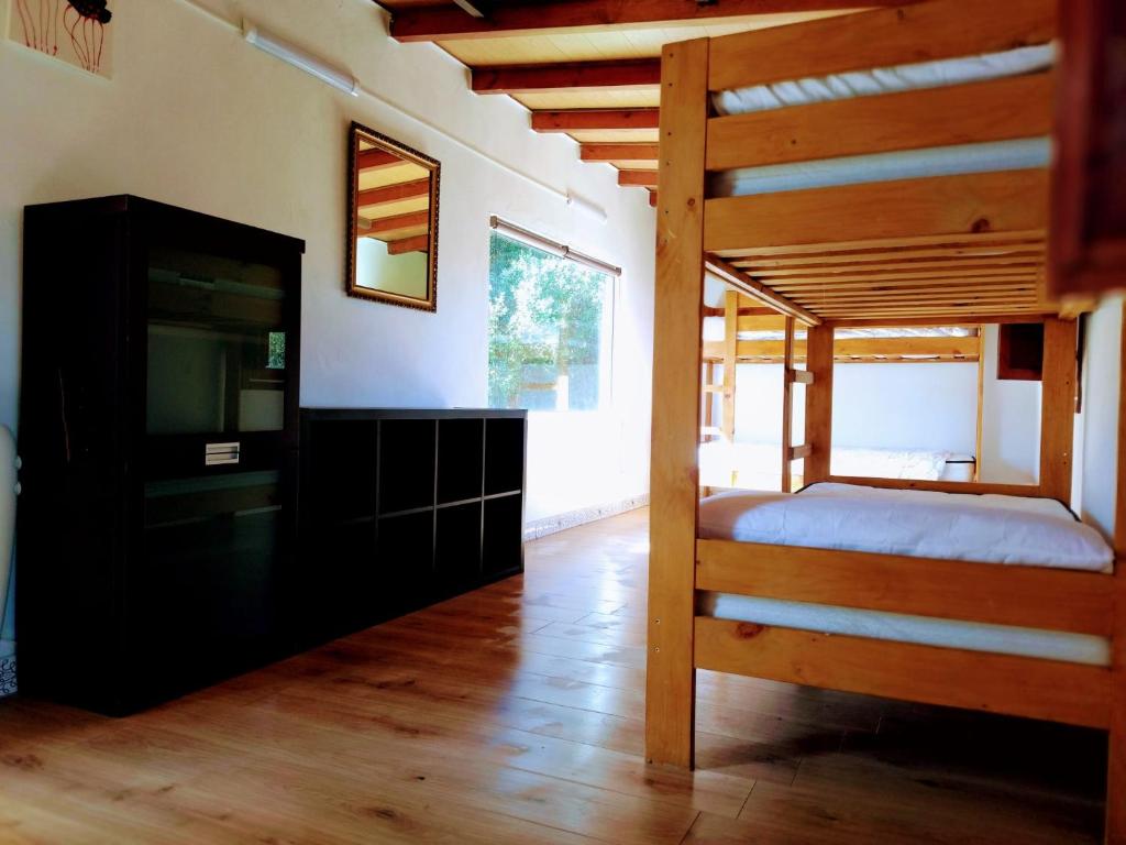 a bedroom with a bunk bed and a television at Surfhousegerra in San Vicente de la Barquera