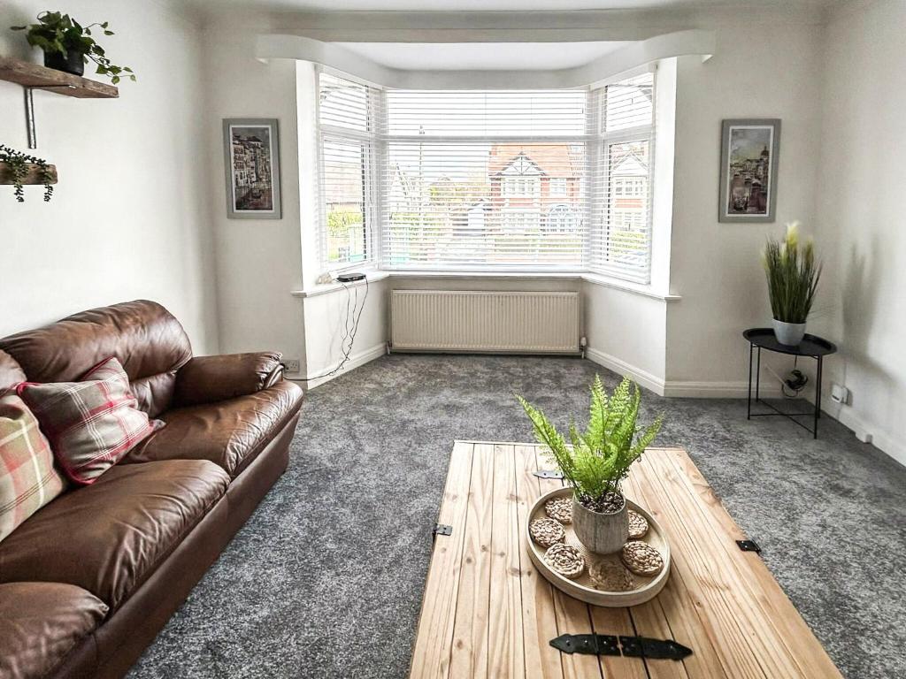 a living room with a couch and a table at Highcross in Poulton le Fylde