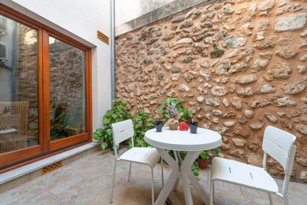 a table and chairs on a patio with a stone wall at Can Puça -Sa Pobla- in Sa Pobla