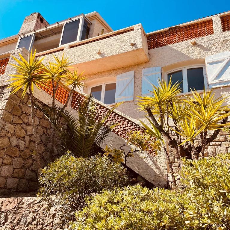 a building with palm trees in front of it at Villa Turquoise Sagone in Sagone