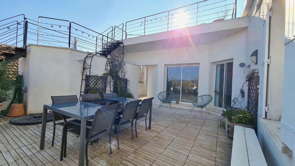 un patio con tavolo e sedie sul balcone. di Au Carpe Diem a Châteauneuf-du-Pape