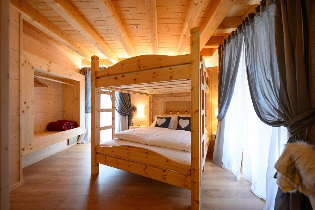 a bedroom with a bunk bed in a wooden house at TerrazzaPaganella in Terlago