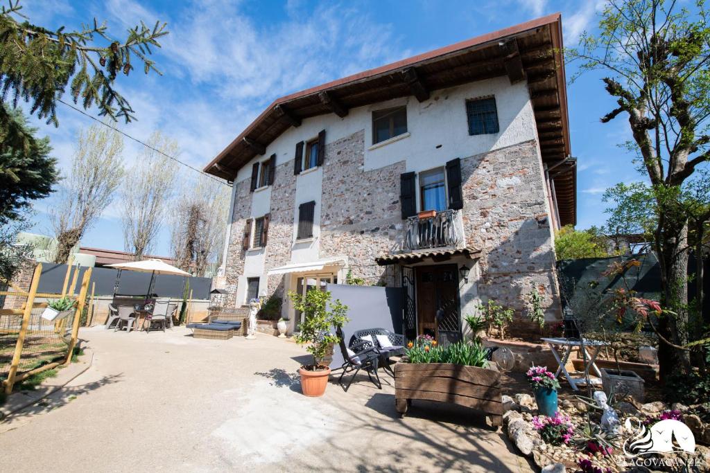 una antigua casa de piedra con un patio frente a ella en Camere Belgioioso, en bedizzol