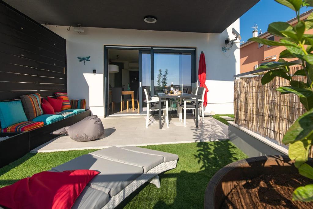 eine Terrasse mit einem Sofa und einem Tisch in einem Haus in der Unterkunft Apartment Libelle 5 star apartment in Krk! in Krk