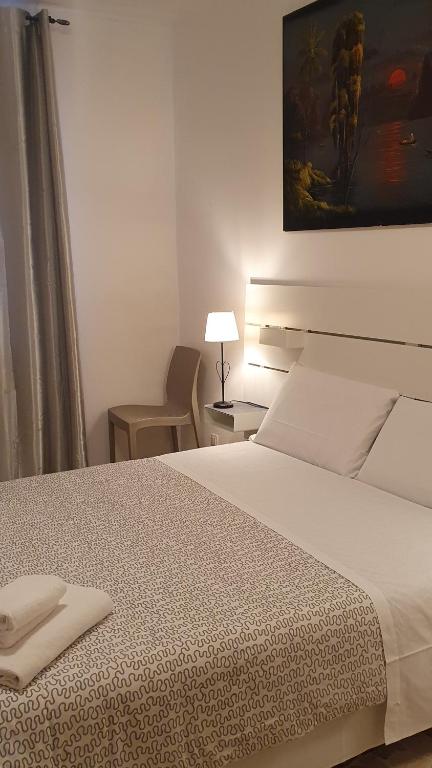 sypialnia z dużym białym łóżkiem i krzesłem w obiekcie Casa del Pozzo w Wenecji