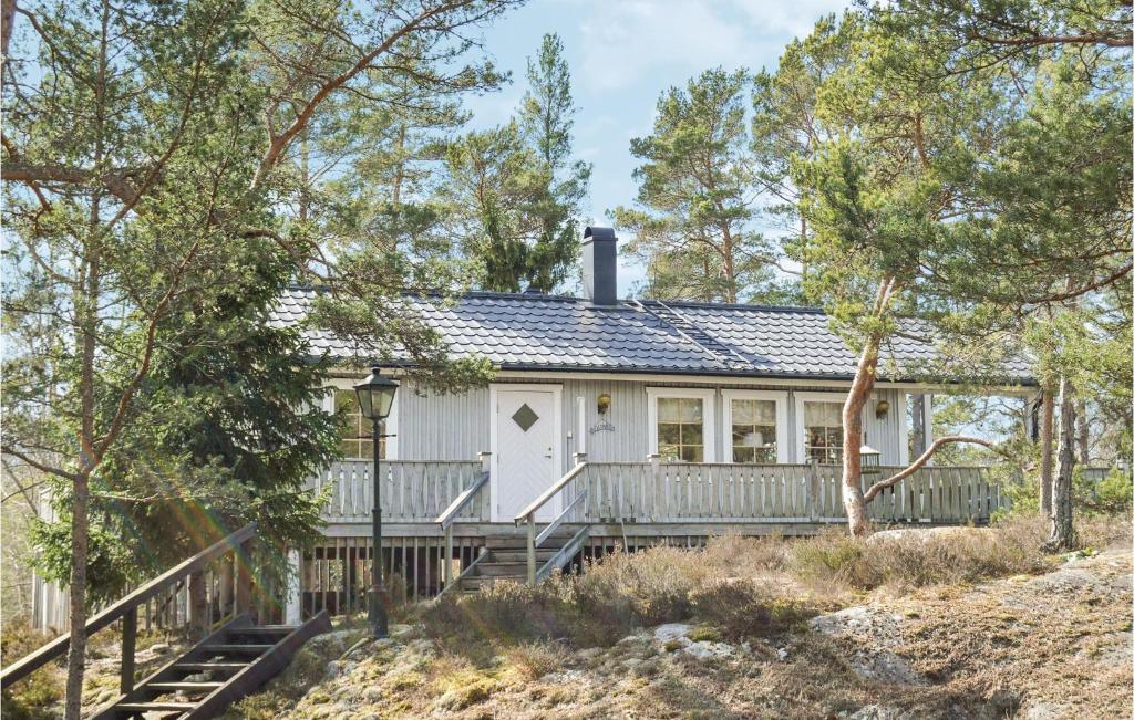 una casa blanca en la playa con árboles en Awesome Home In Djurhamn With 3 Bedrooms, en Djurhamn