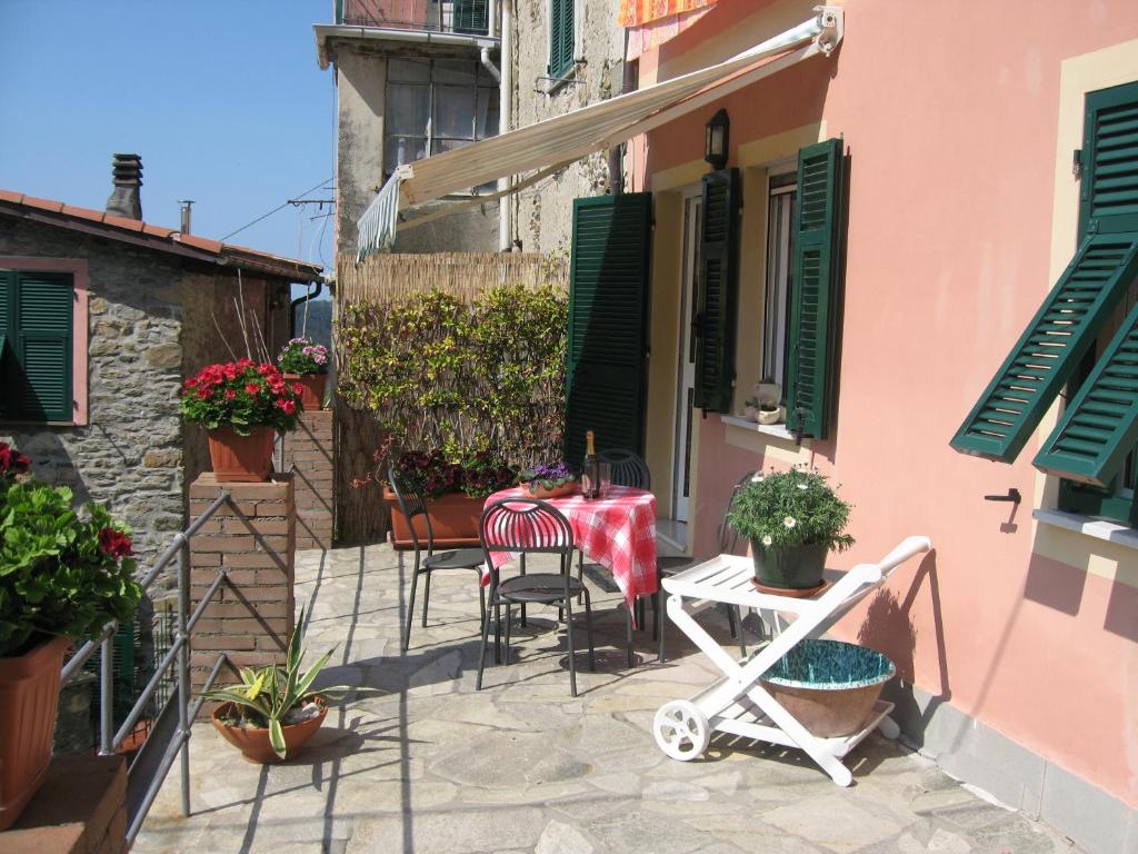 a patio with a table and chairs and plants at Casa Violetta in Levanto