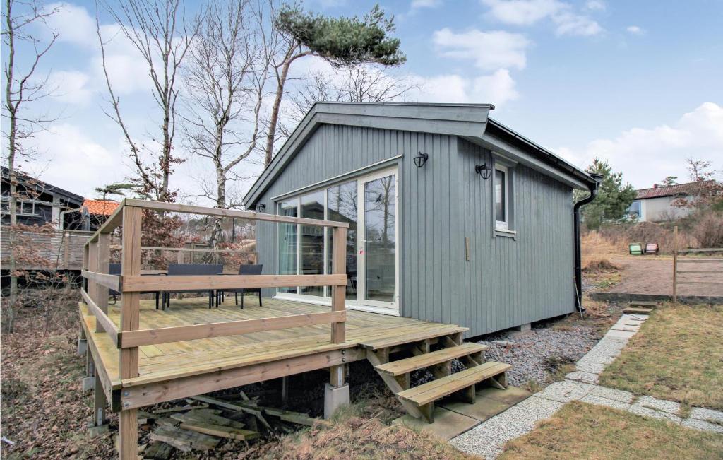 ein kleines grünes Haus mit einer Terrasse und einer Bank in der Unterkunft Pet Friendly Home In Ugglarp With Wifi in Ugglarp