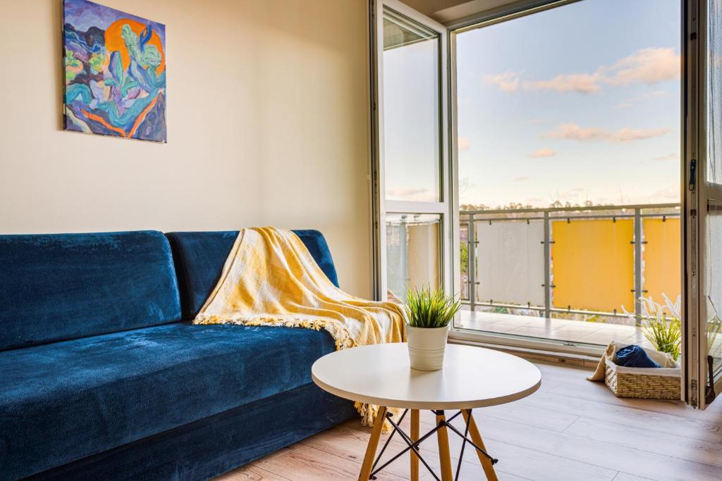 Apartament u Andzi في ستيغنا: غرفة معيشة مع أريكة زرقاء وطاولة