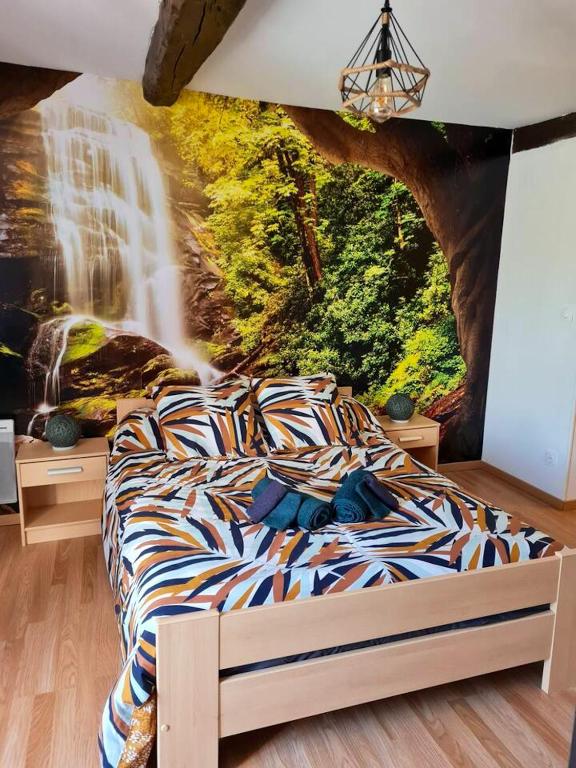 1 dormitorio con 1 cama con un mural de cascada en Maison de 2 chambres avec terrasse a Deville, en Deville
