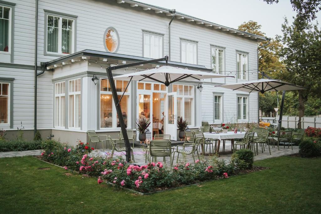 a house with a patio with tables and umbrellas at Old Hapsal Hotel in Haapsalu