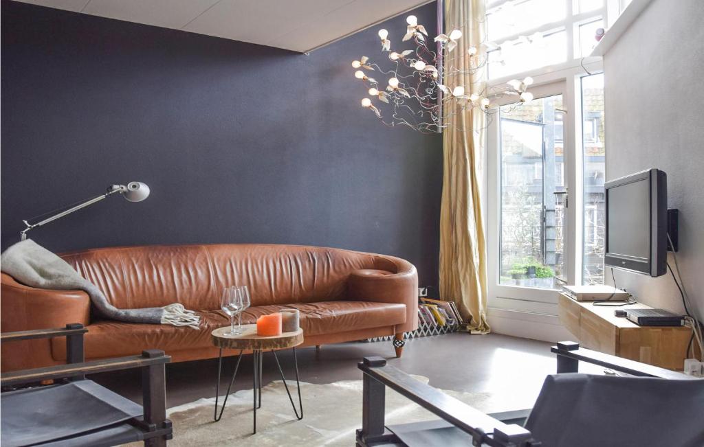 un soggiorno con divano in pelle marrone e TV di Kapeltuin a Hoorn