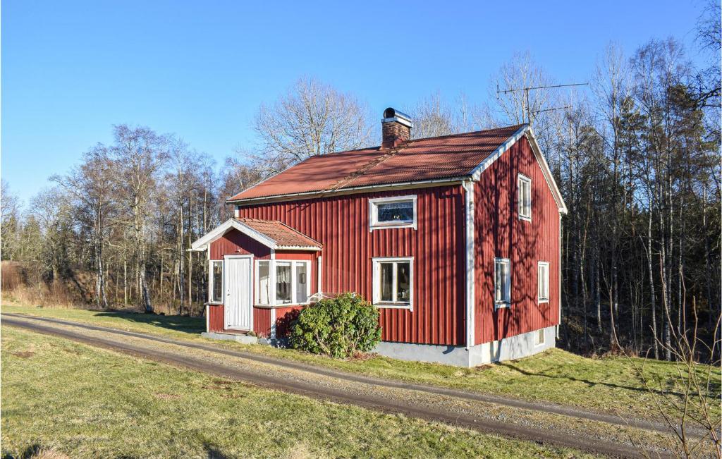 ein rotes Haus am Straßenrand in der Unterkunft Amazing Home In Burseryd With Kitchen in Sjötofta