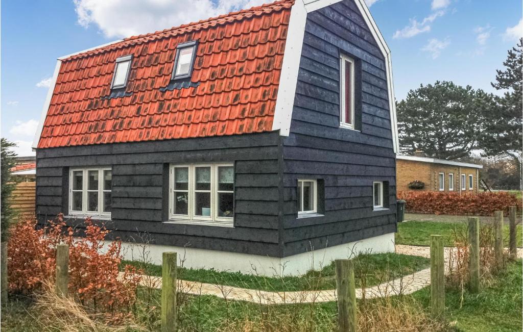 una casa negra con techo rojo en Zandloper, en Egmond aan den Hoef